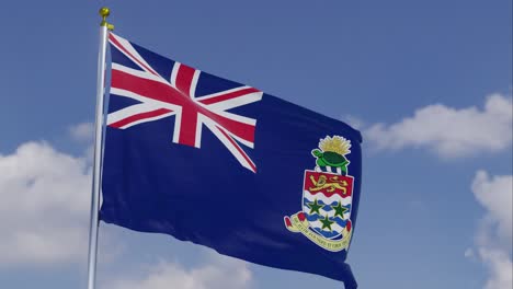 Bandera-De-Las-Islas-Caimán-Moviéndose-En-El-Viento-Con-Un-Cielo-Azul-Claro-En-El-Fondo,-Nubes-Moviéndose-Lentamente,-Asta-De-Bandera,-Cámara-Lenta