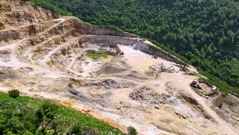 Large-quarry-stone-mining-on-the-side-of-the-mountain-surrounded-by-forest-and-vegetation