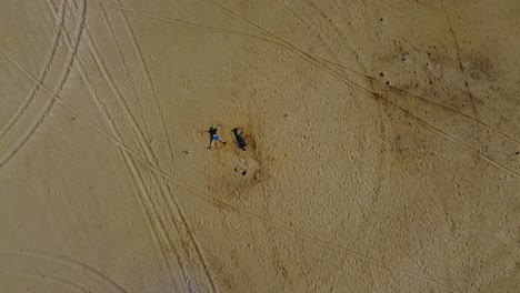 Beach-Fun:-Aerial-Drone-Video-of-Two-Guys-Creating-Sand-Angels-in-Hiiumaa-Island,-Estonia---4K