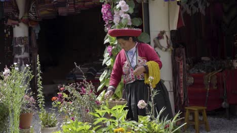 Eine-Junge-Frau-Mit-Traditionellem-Peruanischen-Bunten-Hut-Und-Kleidung,-Während-Sie-Draußen-Gegenstände-In-Einem-Korb-Betrachtet