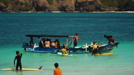 People-boarding-local-boat-for-surfing-trip-in-Lombok,Tanjung-aan,-Kuta,Mandalika-handheld-view