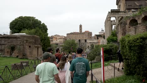 POV-Walking-Behind-Tour-Group-Exploring-The-Roman-Forum-With-A-Guide
