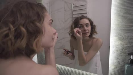 Beautiful-woman-using-eyebrow-pencil-make-up-in-front-mirror.-Happy-female-using-beauty-cosmetics-to-improve-herself-ready-to-working-in-bathroom-at-home.-Lifestyle-women-relax-at-home