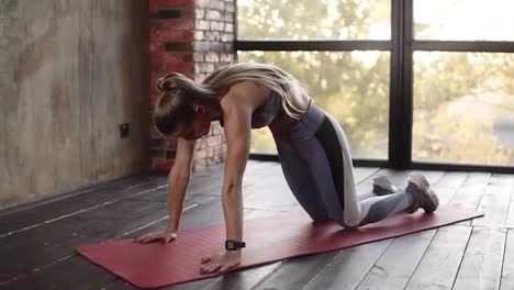 Flexible-Frau-übt-Morgens-Yoga-Stellungen-Oder-Macht-Dehnübungen-Im-Leeren-Studio,-Mädchen-In-Grau-Macht-Atemübungen-Und