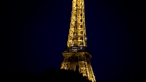 Eiffel-Tower-seen-at-night-from-the-Seine-river-with-night-lights,-View-from-boat