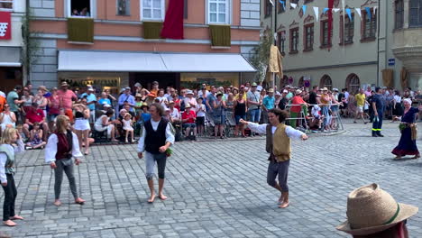 Medieval-entertainers-do-a-backflip-in-costumes-at-the-Parade-at-the-Landshut-wedding,-a-historical-celebration-of-1475-that-is-reenacted-every-4-years,-Landshut,-Germany