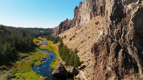 river-running-through-smith-rock-state-park,-drone-push-in,-Oregon