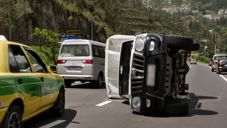 Overturned-car-on-busy-Quito-road,-Ecuador