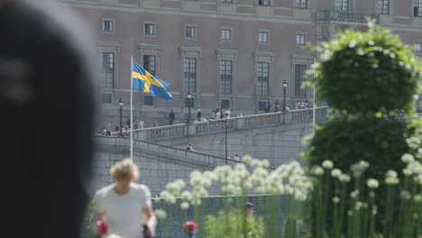 Flag-by-Swedish-Royal-Palace-in-Stockholm-on-National-Day,-slomo