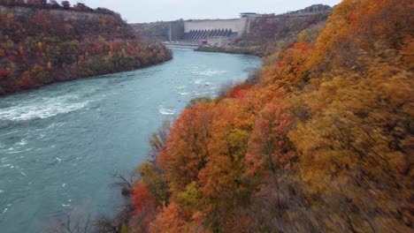 aerial-pov-fly-through-the-niagara-gorge-during-autumn-season-with-a-bright-and-colorful-scenery-below-with-tons-of-orange-and-yellow-colors,-typical-of-autumn-season