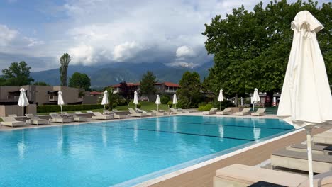 View-from-the-pool-of-Dion-Palace-Resort-and-Spa-against-the-backdrop-of-Mount-Olympus,-the-highest-mountain-in-Greece,-shrouded-in-large-white-clouds