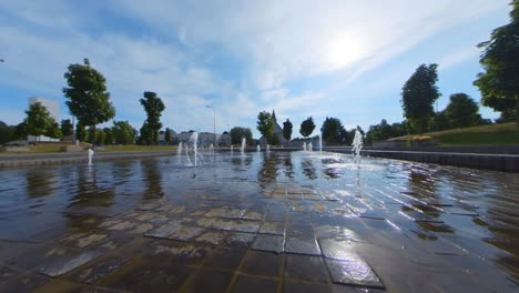 Slow-Motion-Shot-Of-Movement-over-City-Fountain-Towards-Modern-Church