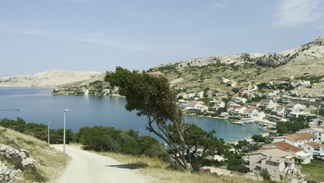 Road-towards-village-Metajna-on-island-Pag-in-Croatia,-summer-blue-sky-and-Adriatic-Sea