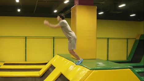 Young-sportive-boy-having-the-time-of-his-life-enjoying-jumping-on-trampoline.-Performing-handspring-flips.
