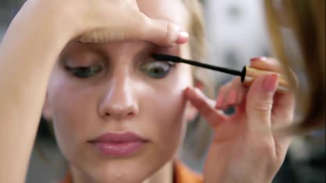 Make-up-artist-applying-eyelash-makeup-to-model's-eye.-Mascara-.Close-up-view