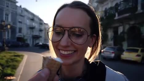 Close-up-footage-of-a-young-woman-face-in-glasses-taking-and-ice-cream-from-malee-hand.-Friendship,-having-fun,-smiling.-Outside