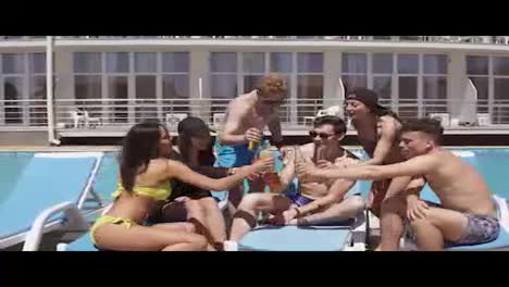 Group-of-beautiful-young-friends-in-swimsuits-drinking-cocktails-with-cheers-and-having-fun-sitting-by-the-swimming-pool.-Shot-in-4k