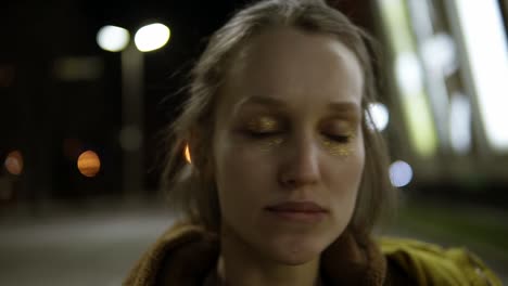 A-girl-with-golden-sequins-on-her-eyelids-closed-her-eyes-dances-in-the-street.-Emotional.-Sensually