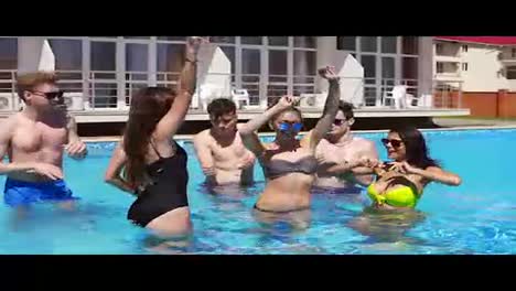 Happy-young-cheerful-friends-dancing-and-having-fun-in-the-pool-cooling-off-in-the-water-on-a-hot-summer-day.-Summertime-pool-party.-Slowmotion-shot.