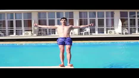 Young-athletic-man-in-swim-shorts-falling-to-the-swimming-pool.-Slowmotion-shot.