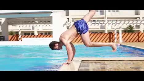 Young-athletic-man-in-swim-shorts-running-and-jumping-to-the-swimming-pool-standing-on-his-hands.-Slowmotion-shot.