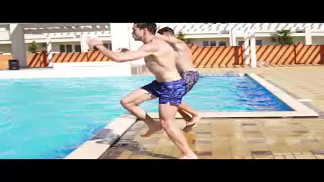 Two-young-athletic-men-in-swimshorts-running-and-jumping-to-the-swimming-pool-turning-around.-Slowmotion-shot.