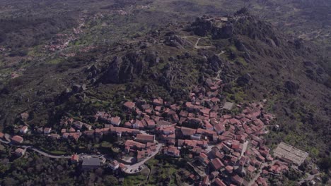 Top-down-shot-of-village-of-Monsanto-Portugal-with-castle-on-hill-top,-aerial