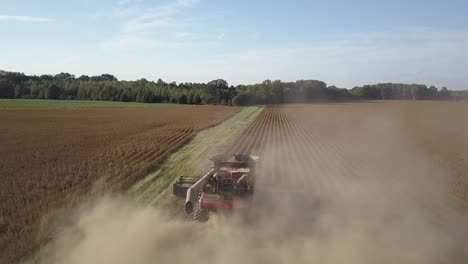 Flyover-Combine-Tractor-Harvesting-Crop-In-Dust-Bean-Field-On-Sunny-Day-Hardworking-Farmer