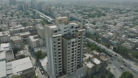 Aerial-drone-shot-of-high-rise-building-and-busy-city-streets-in-Karachi,-Pakistan