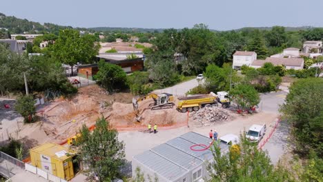 Aerial-view-of-bulldozer-digging-sand-and-putting-it-in-the-truck-on-a-construction-site