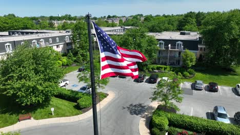 An-Einem-Klaren-Sommertag-Wehte-Die-Amerikanische-Flagge-Im-Wind-In-Einem-Von-Apartmentkomplexen-Umgebenen-Innenhof