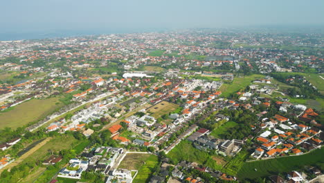Aerial-view-over-Canggu-CIty-with-housing-area-and-ocean-in-background-in-summer---Top-down-during-foggy-day