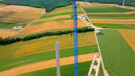 Windmill-Construction-With-Crane-In-Austria---aerial-drone-shot