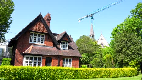 Charming-brick-house-in-Saint-Stephen's-Green-Park-with-church-and-crane-in-background,-Dublin