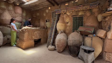 Tunisian-potter-teaches-tourist-little-girl-to-work-clay-in-his-rural-workshop