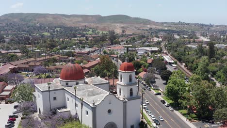 Descending-close-up-aerial-shot-of-the-Mission-Basilica-belltower-in-San-Juan-Capistrano,-California