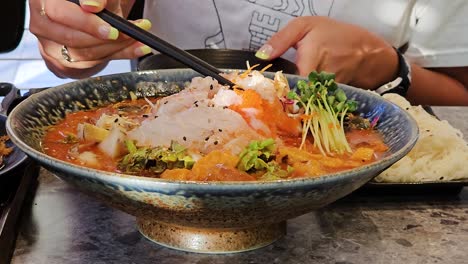 Mujer-Comiendo-Sopa-Fría-De-Pescado-Crudo-Mulhoe-Dentro-Del-Restaurante-Coreano