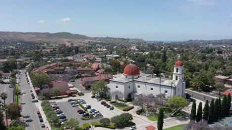 Aerial-wide-panning-shot-of-the-Mission-Basilica-with-the-Mission-San-Juan-Capistrano-in-the-background-in-California