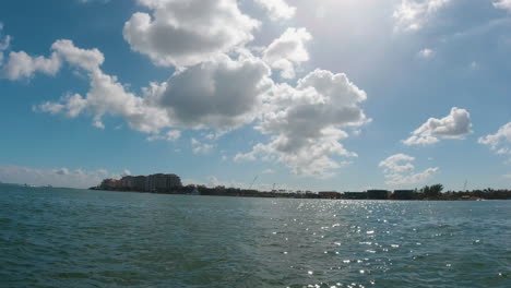 Bootsblick-Auf-Die-Küste-Der-Biscayne-Bay,-Florida,-Mit-Der-Sonne,-Die-Sich-Im-Wasser-Spiegelt