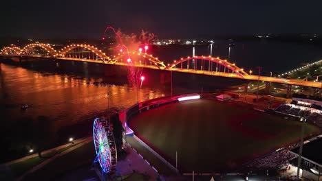 Davenport,-Iowa-at-night-with-fireworks-going-off-after-Quad-Cities-River-Bandits-game-and-drone-video-moving-in-circle-left-close-up
