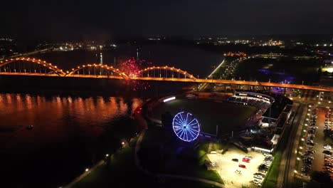 Davenport,-Iowa-at-night-with-fireworks-going-off-after-Quad-Cities-River-Bandits-game-and-drone-video-moving-in-close-up