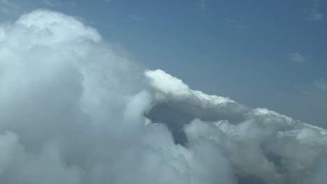 Ein-Einzigartiger-Pilotenblick,-Während-Er-In-Einem-Jet-über-Einen-Himmel-Mit-Einigen-Winzigen-Kumuluswolken-Fliegt