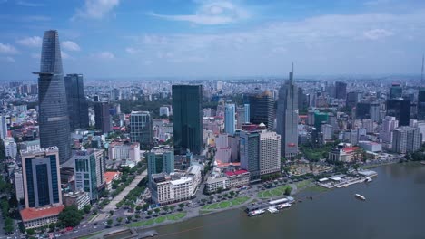 Aerial-view-of-Ho-Chi-Minh-City-skyline-featuring-key-buildings,-with-Saigon-River-waterfront-on-a-sunny,-clear-day