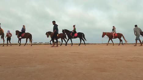 Touristen-Reiten-Auf-Pferden-Und-Dromedaren-Hintereinander-Durch-Die-Wüste-Tunesiens