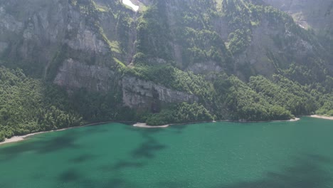 Terreno-Montañoso-Rocoso-Bañado-Por-El-Sol-Con-Agua-De-Lago-Turquesa-En-Suiza