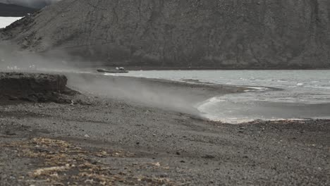 Steam-is-rising-over-beach-from-water-fast,-close-to-volcano