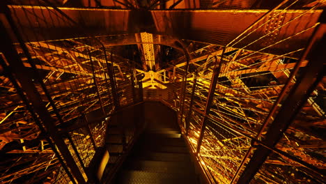 Walking-Down-The-Stairs-Inside-The-Famous-Eiffel-Tower-At-Night-In-Paris,-France