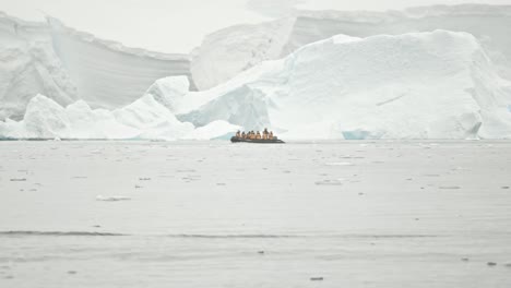 Guest-on-board-of-boat-cruise-past-a-big-glacier-in-snow-storm,-very-dramatic