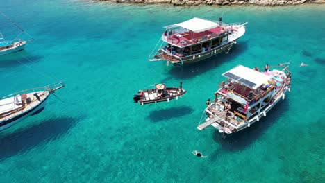 Drone-of-boats-floating-in-shallow-crystal-blue-waters-on-the-Turkish-Riviera-in-Bodrum