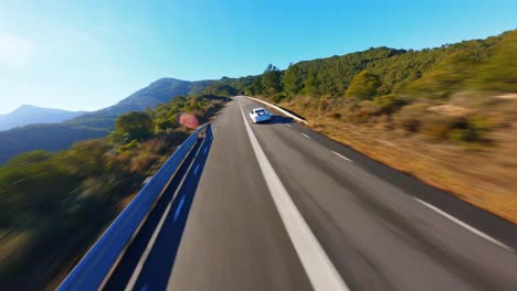 Scenic-FPV-aerial-following-a-Porsche-911-GT3-along-a-picturesque-mountain-road